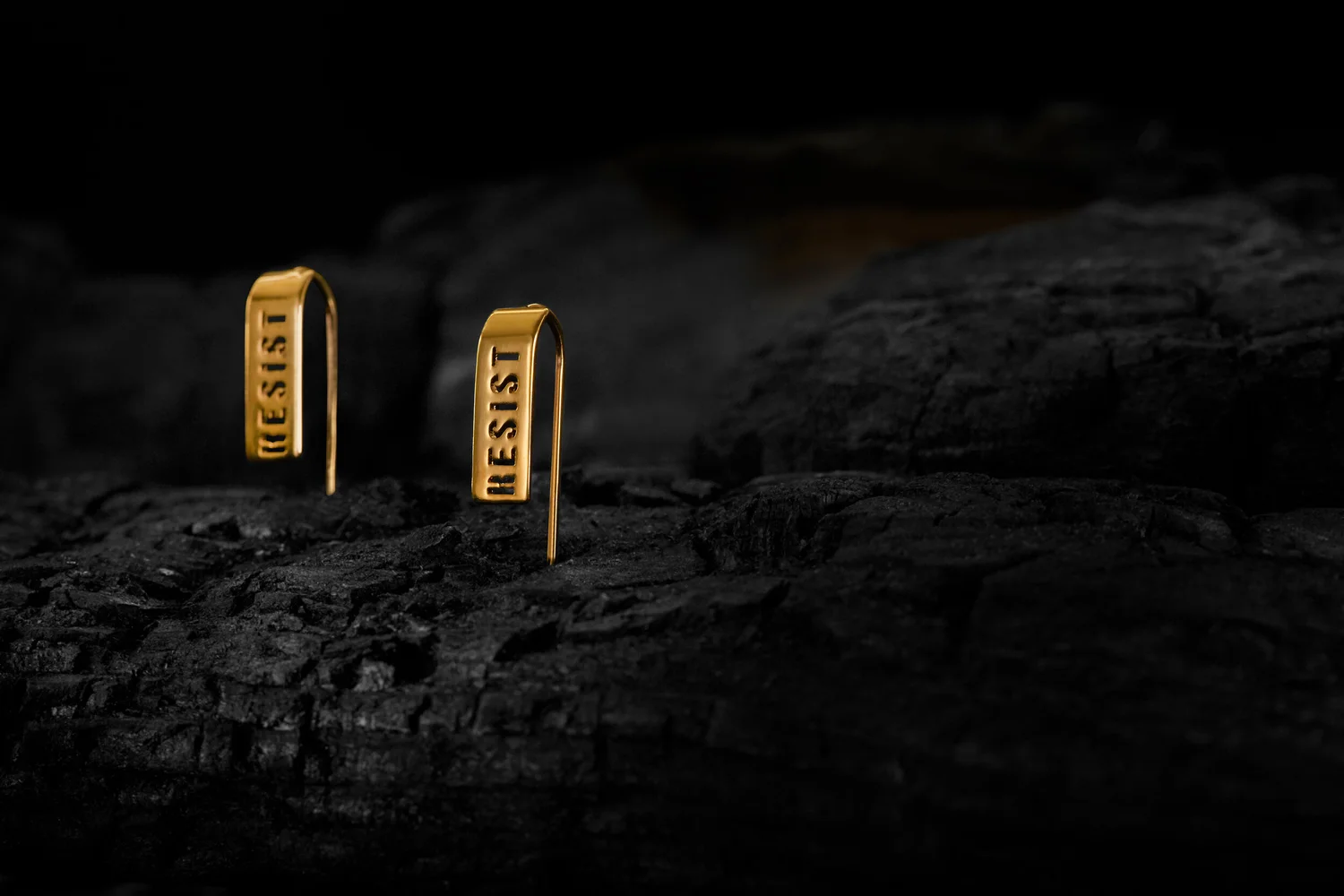 Resist earrings on charred wood