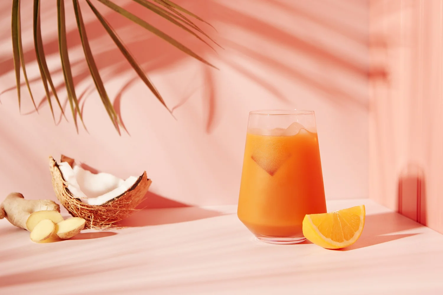 Juice with coconut and ginger on pink